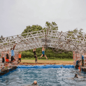 People tackling outdoor obstacle course over water