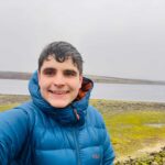 Person taking selfie by a misty lakeside