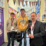 Camera crew filming inside a decorated school hallway