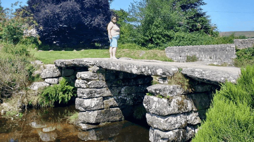 Katie Standing on a bridge with water underneath.
